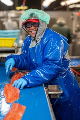 Team member cleaning salmon in one of our facilities