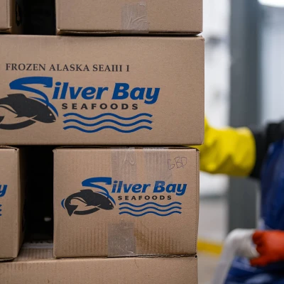 Silver Bay Seafoods boxes in a stack next to a worker