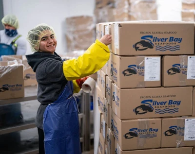 Silver Bay Seafoods boxes in a stack next to a worker
